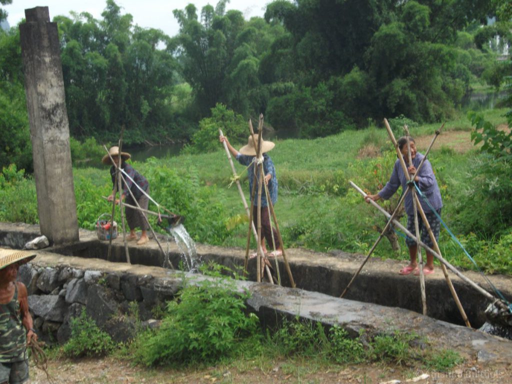 Vrouwen die water pompen uit een rivier